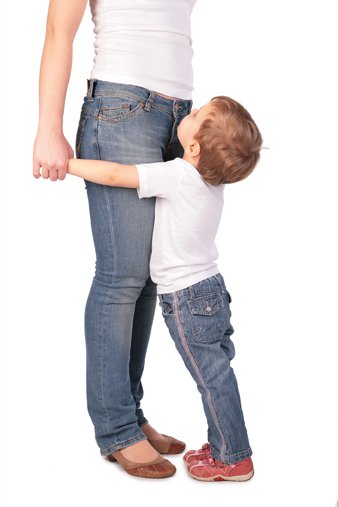 child holding onto mother's legs