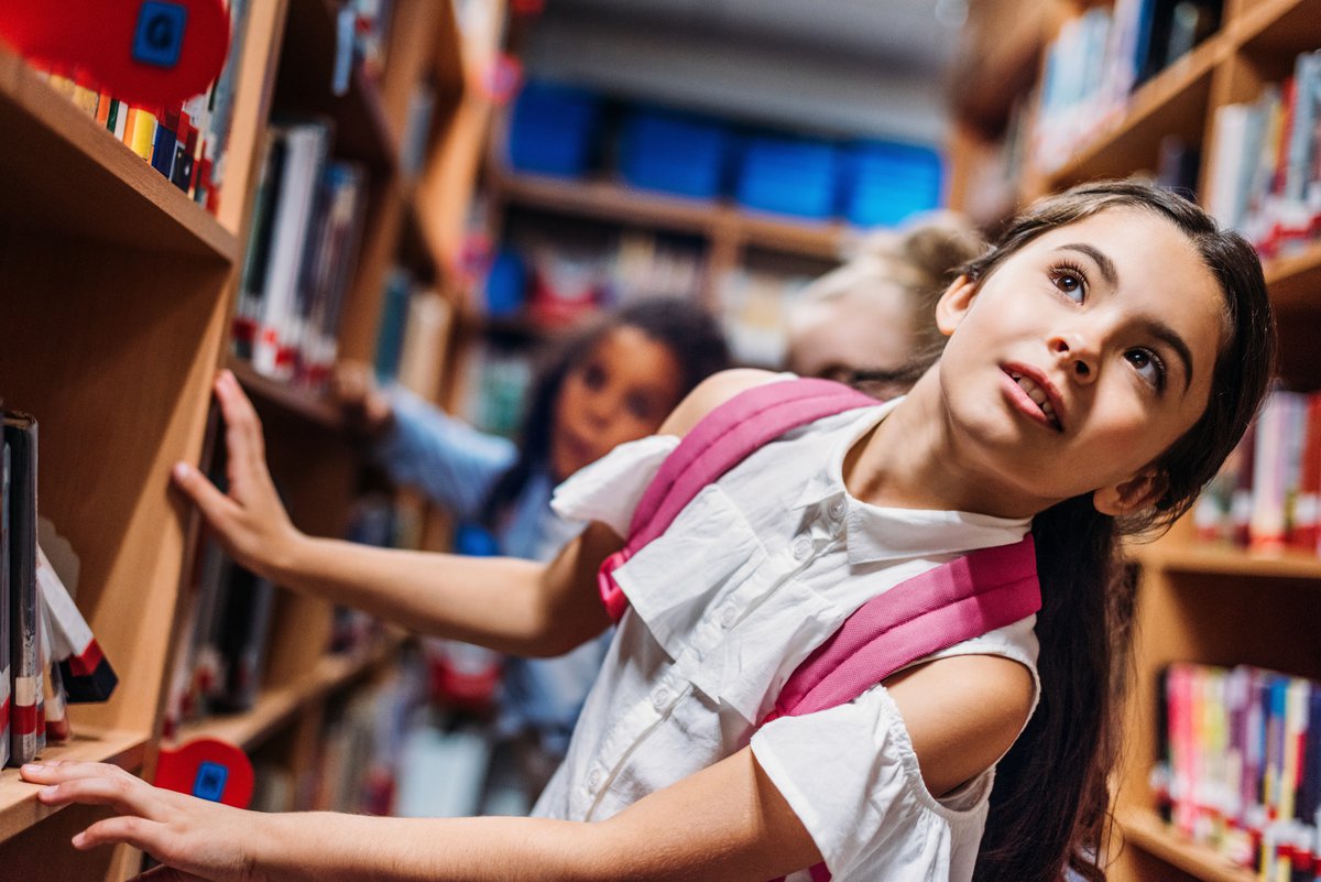 Family library share. Школьная фотосессия в библиотеке. Дети ищут книги. Дети в университете. Красивые маленькие школьницы.