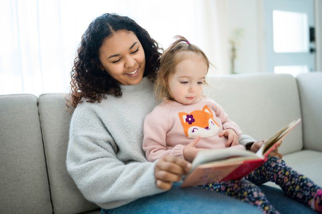 babysitter reads book with little child girl