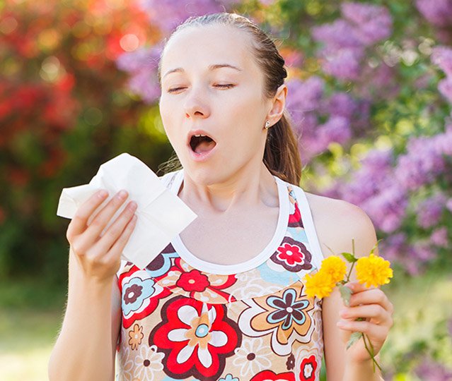 woman sneezing seasonal allergies