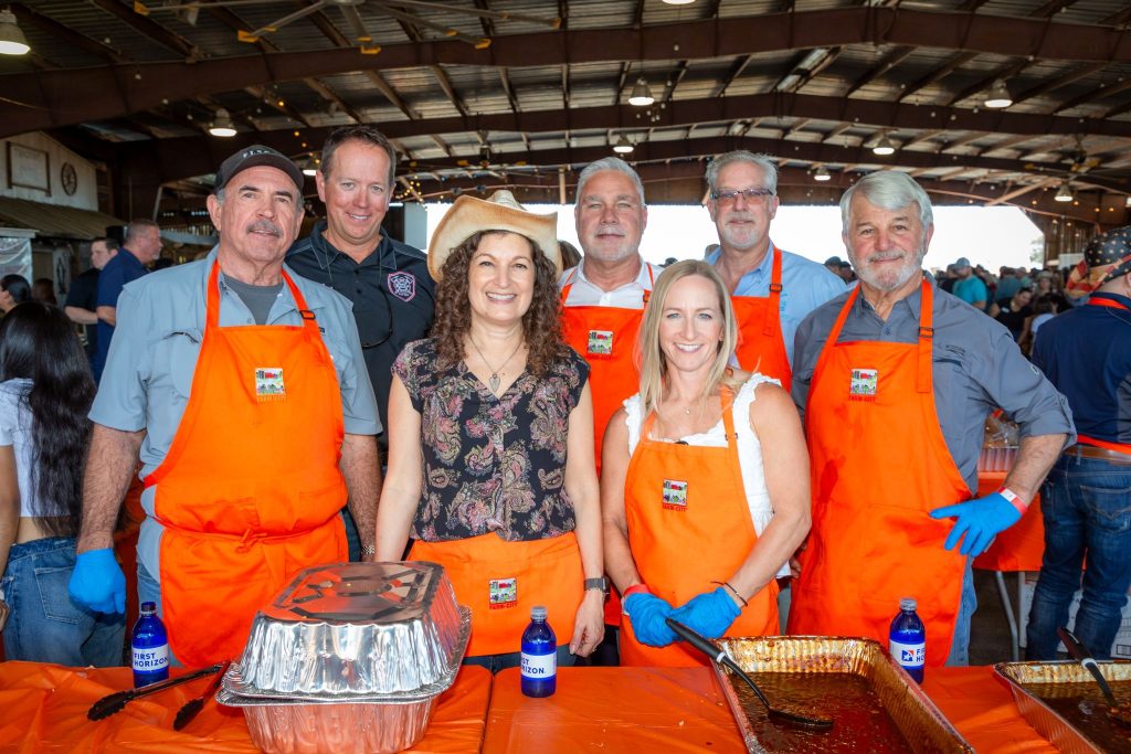 Local celebrities serving BBQ at Farm City BBQ.